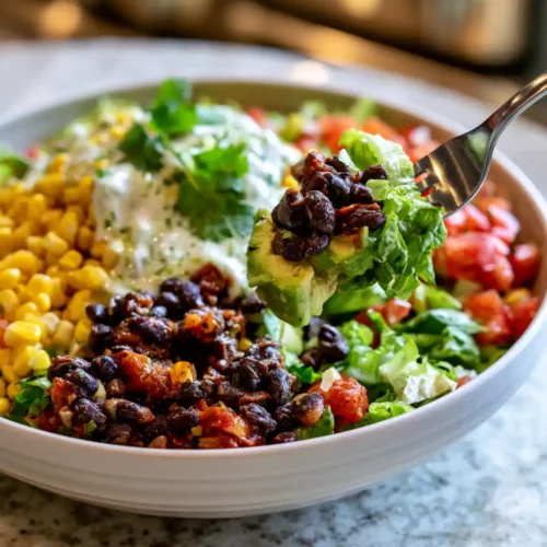Vegetarian black bean taco salad with corn, avocado, and tomatoes in a bowl